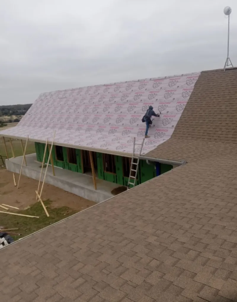 Worker preparing underlayment for a metal roof installation in Lebanon